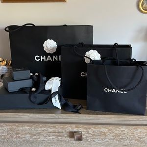 Various sizes of Chanel gift bags, gift boxes and ribbons.